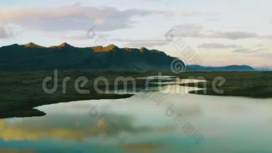 无人机飞过水面，美丽的山形倒影进入<strong>靠近</strong>火山土地的小湖。冰岛的汽车在<strong>高速</strong>公路上行驶。